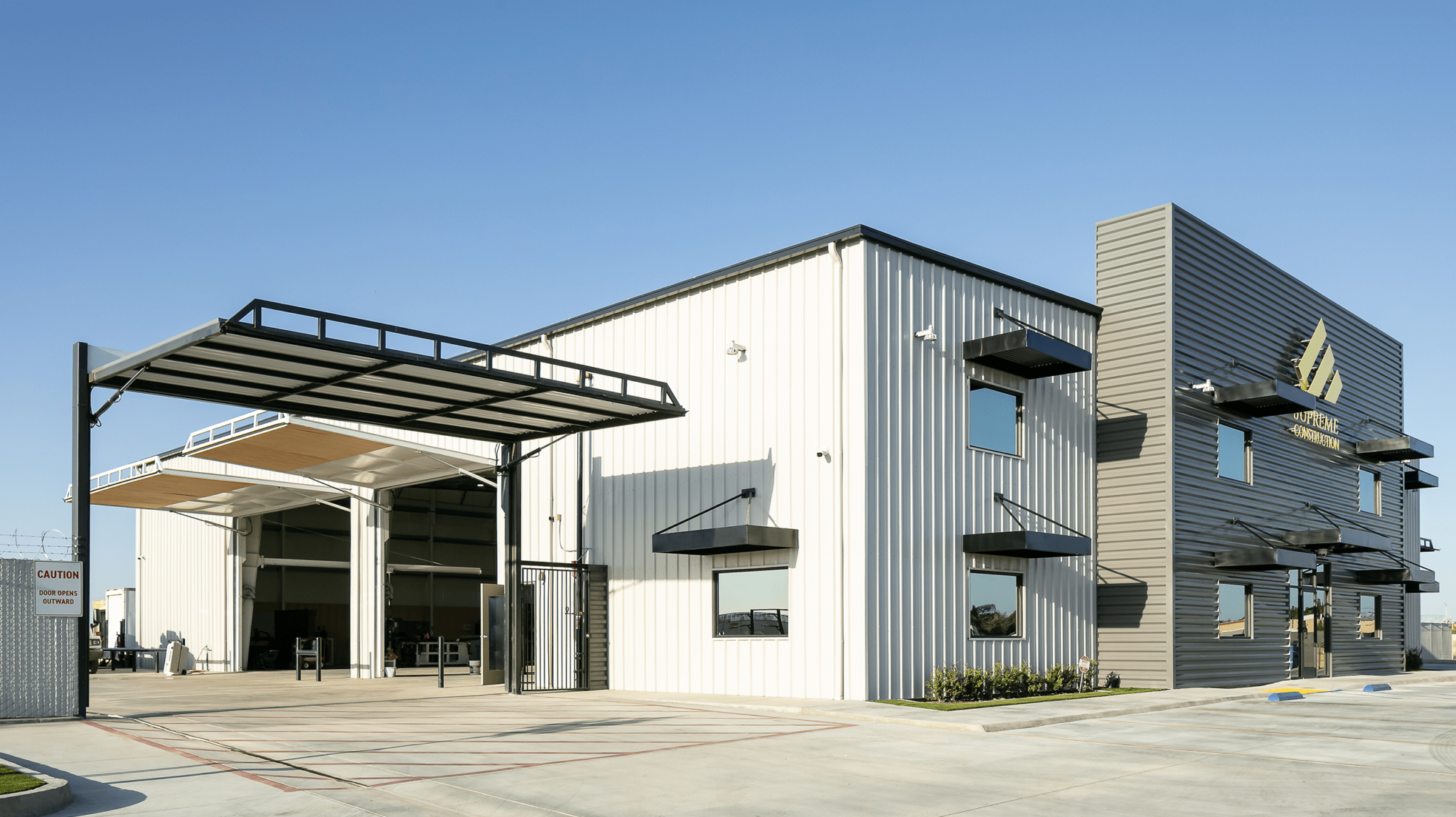 Pre-engineered metal commercial building with covered service bay and modern office façade.